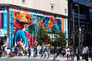 東京建築物上的動漫角色壁畫，行人正在過馬路。 — MacBook Air M4 壁紙