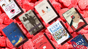 各種書本封面散落在紅色心形糖果上。 — 日子流逝 壁紙