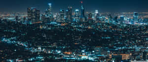 密集城市天際線嘅夜景，建築物燈火通明。 — 熱帶海灘 壁紙