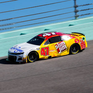 白天在賽道上飛馳的黃色和白色NASCAR賽車。 — 汽車 壁紙
