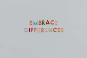 色彩繽紛的磁石字母在灰色牆上拼出 embrace differences。 — MacBook Air 15 壁紙