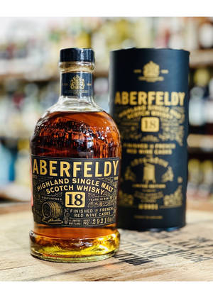 Aberfeldy 18年威士忌酒瓶和盒子放在店內木質櫃檯上。