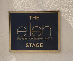 安裝在有紋理牆上、陽光照射下的The Ellen DeGeneres Show Stage標誌。