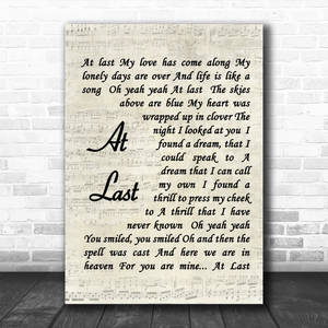 一幅在磚牆上的'At Last'歌詞海報。 — 音樂 GIF 壁紙