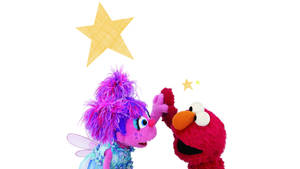 Elmo 同一個紫色仙女木偶喺白色背景上伸手去摸星星。