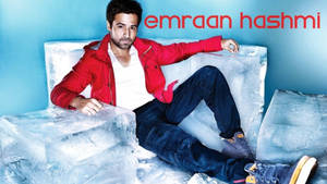 演員 Emraan Hashmi 穿著紅色外套，靠在一塊大冰塊上，背景為藍色。 — 冰 GIF 壁紙