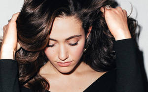 深色頭髮的女性在攝影棚肖像中閉著眼睛握著髮絲。 — 音樂 GIF 壁紙