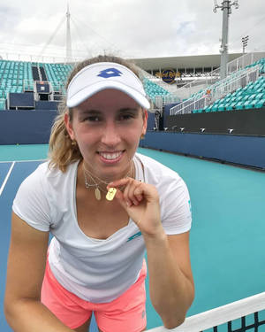 女網球選手喺球場上微笑並高舉金牌。 — 運動 壁紙