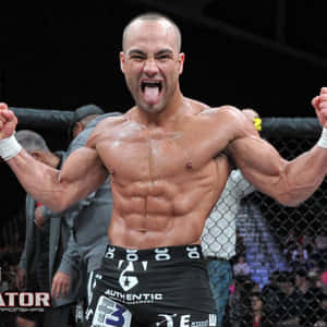 肌肉發達的拳手在MMA籠中高舉拳頭、伸出舌頭慶祝勝利。