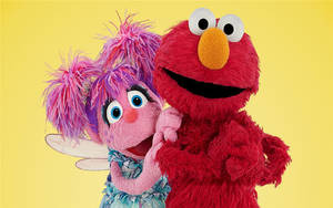 Elmo 同仙女公仔用鮮豔顏色擁抱。