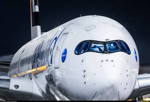 夜晚白色空中巴士A380飛機機頭的近距離特寫，藍色駕駛艙窗戶。