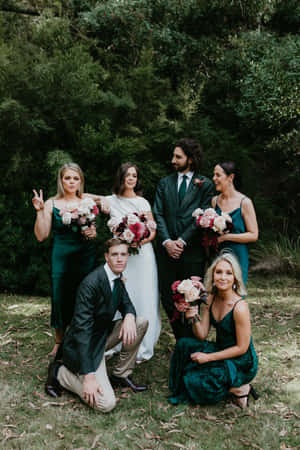 婚禮派對在森林中穿著綠色連衣裙和花束拍照