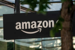 透過玻璃建築附近的樹葉看到的Amazon標誌