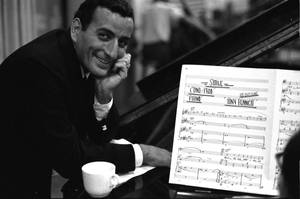 Tony Bennett 在鋼琴旁微笑，旁邊有《Smile》樂譜。