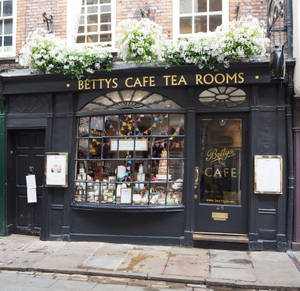 Betty's Cafe Tea Rooms 的店面，透過窗戶可以看到花箱和色彩繽紛的彩旗。