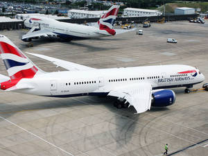 兩架英國航空飛機在機場停機坪上，有地勤人員和車輛。 — 飛機 壁紙