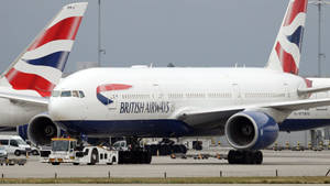 英國航空空中巴士A380在機場停機坪上，有地勤服務車輛。