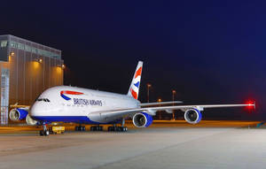 英國航空A380飛機在夜間停泊在機場停機坪上，靠近客運大樓。