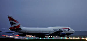 英國航空波音747在黃昏時分在跑道上滑行，燈光亮起。