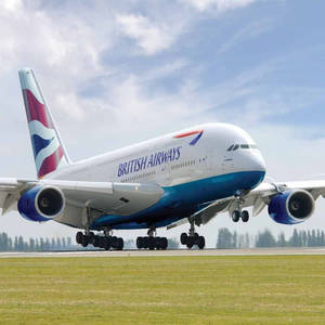 英國航空A380飛機從跑道起飛，背景有綠色草地和樹木。