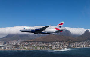 英國航空A380飛越有山脈和海洋的沿海城市。