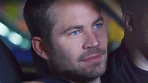 Paul Walker 在夜間車內，身後有模糊的燈光。 — 狂野時速 壁紙
