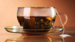 一個玻璃茶杯，內有茶包和方糖，放在茶托上。
