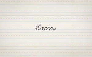 「Learn.」一詞以草書寫在橫線筆記本紙上。