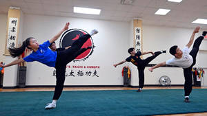 四名武術學生在道場練習高踢腿。