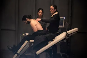 兩名醫療專業人員在檢查床上檢查一名赤裸上身的病人。