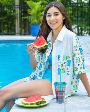 女士在夏天於泳池邊吃西瓜