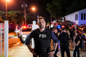 夜間犯罪現場的FBI探員，有警察和閃爍燈光。