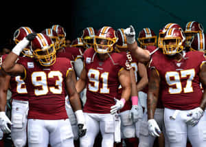華盛頓美式足球隊球員身穿栗色和金色制服在球場上行走。 — NFL 美式足球 GIF 壁紙
