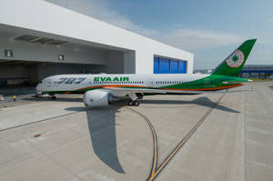 陽光明媚的日子裡，EVA AIR波音787夢幻客機停在機場機庫