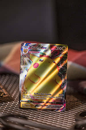 紋理金屬表面上的閃亮比卡超VMAX Pokémon卡，帶有全息金色箔片。