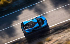 一輛藍色Bugatti超級跑車在陽光明媚的道路上疾馳，帶有動態模糊。