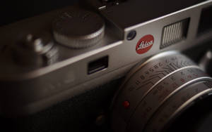 銀色 Leica 相機的特寫，帶有紅色標誌和鏡頭標記。