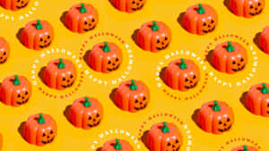 黃色背景上帶綠色莖的橙色塑膠南瓜重複圖案，並有 'happy halloween' 文字。 — 萬聖節 壁紙