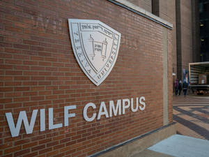 帶有 Wilf Campus 標牌及大學徽章的磚牆