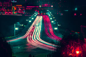 汽車的霓虹燈軌跡在夜間劃過城市街道。 — 夜晚 GIF 壁紙