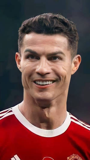 Cristiano Ronaldo 穿著紅色曼聯足球球衣微笑。