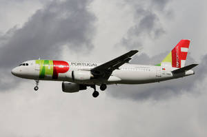 TAP葡萄牙航空飛機放下起落架在多雲天空下飛行。