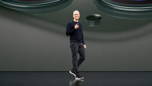 Tim Cook 在科技舞台上行走，向觀眾微笑