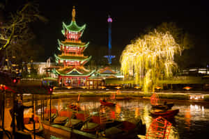 節日夜景，發光的寶塔和柳樹倒映在運河中，伴有船隻。 — 湖 壁紙