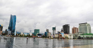 濕潤的城市廣場，摩天大樓和多雲天空的倒影 — 灰色 GIF 壁紙