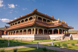 宏偉的傳統中國寺廟，紅色和金色屋頂，藍天之下。