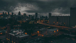 黃昏時分的城市景觀，帶有風暴雲和閃爍的路燈。 — 天際線 壁紙
