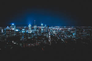 夜晚充滿活力的城市景觀，摩天大樓在黑暗的天空下閃閃發光。 — 夜景城市 壁紙