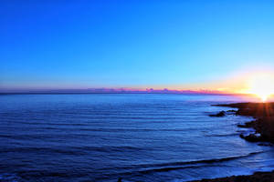 海洋上的夕陽，岩石海岸和鮮豔的天空色彩