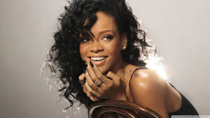 Rihanna 在工作室肖像中微笑，捲髮和綠色指甲。